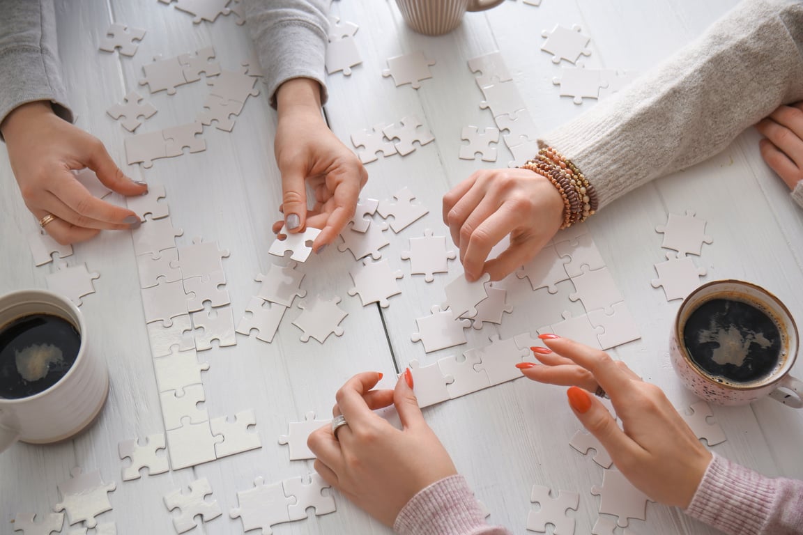 People Doing Puzzle at Table